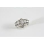 AN ART DECO DIAMOND RING centred with a row of graduated old brilliant-cut diamonds within a