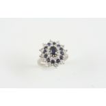 A SAPPHIRE AND DIAMOND CLUSTER RING the oval-shaped sapphire is set within a triple surround of