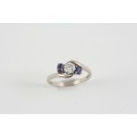 A SAPPHIRE AND DIAMOND CROSS-OVER RING the brilliant-cut diamond is set with two oval-shaped