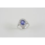 A SAPPHIRE AND DIAMOND CLUSTER RING the oval-shaped sapphire is set within a surround of two