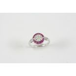 A RUBY AND DIAMOND CLUSTER RING the central circular-cut diamond is set within a surround of