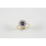 A SAPPHIRE AND DIAMOND CLUSTER RING the oval-shaped sapphire is set within a surround of ten