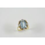 AN AQUAMARINE AND DIAMOND RING the step-cut aquamarine is set within a gold surround mounted with