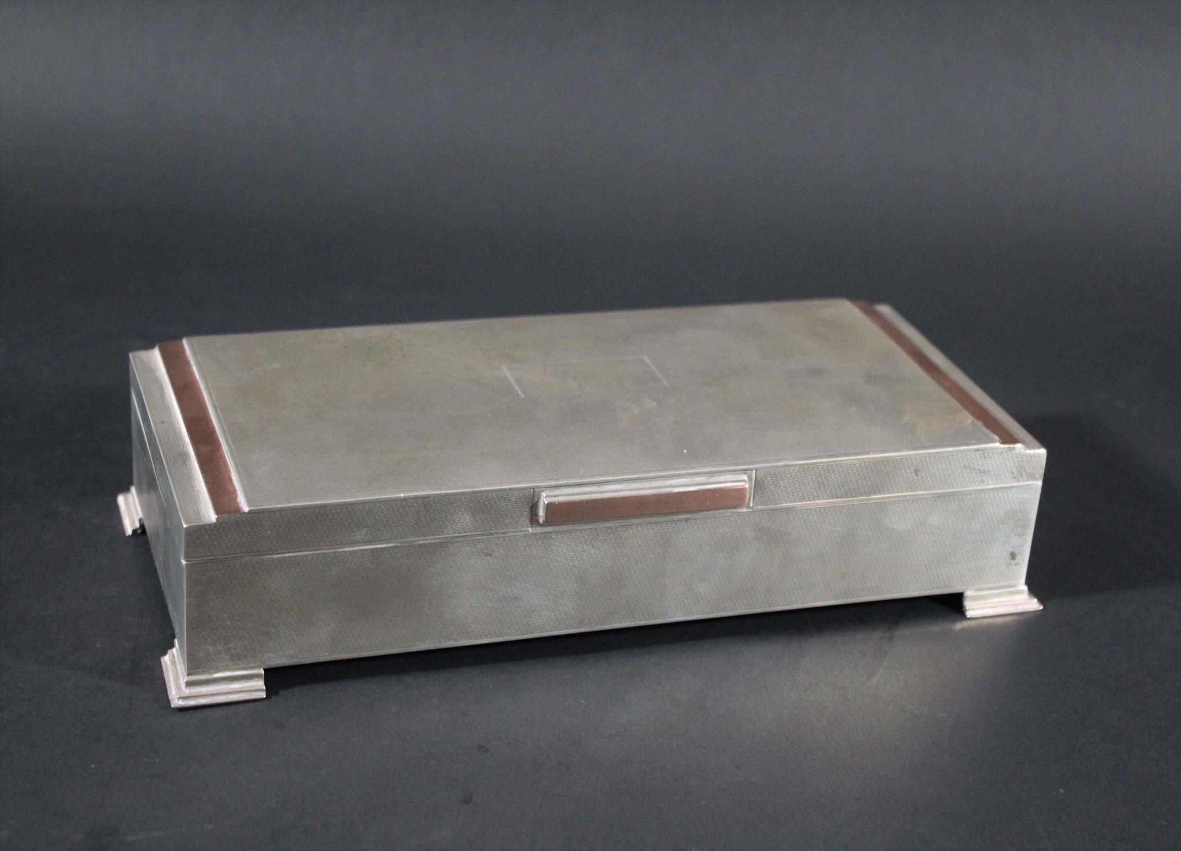 ART DECO STYLE SILVER CIGARETTE BOX a silver cigarette box with bands of copper and a lined wooden