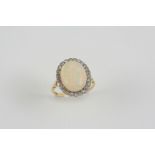 AN OPAL AND DIAMOND CLUSTER RING the oval-shaped solid white opal is set within a surround of