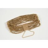 A 9CT. GOLD BRACELET formed as seven rows of circular-shaped links to a rectangular gold clasp,