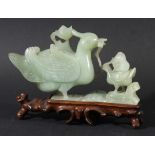 CHINESE CELADON JADE GROUP, carved as a duck and ducking, on a hardwood stand, length 19cm