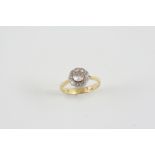 A DIAMOND CLUSTER RING the central old brilliant-cut diamond is set within a surround of circular