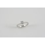 A DIAMOND SOLITAIRE RING set with a round brilliant-cut diamond, in platinum. Size K. Accompanied by