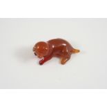 A CARVED CORNELIAN DOG 5.5cm. long.