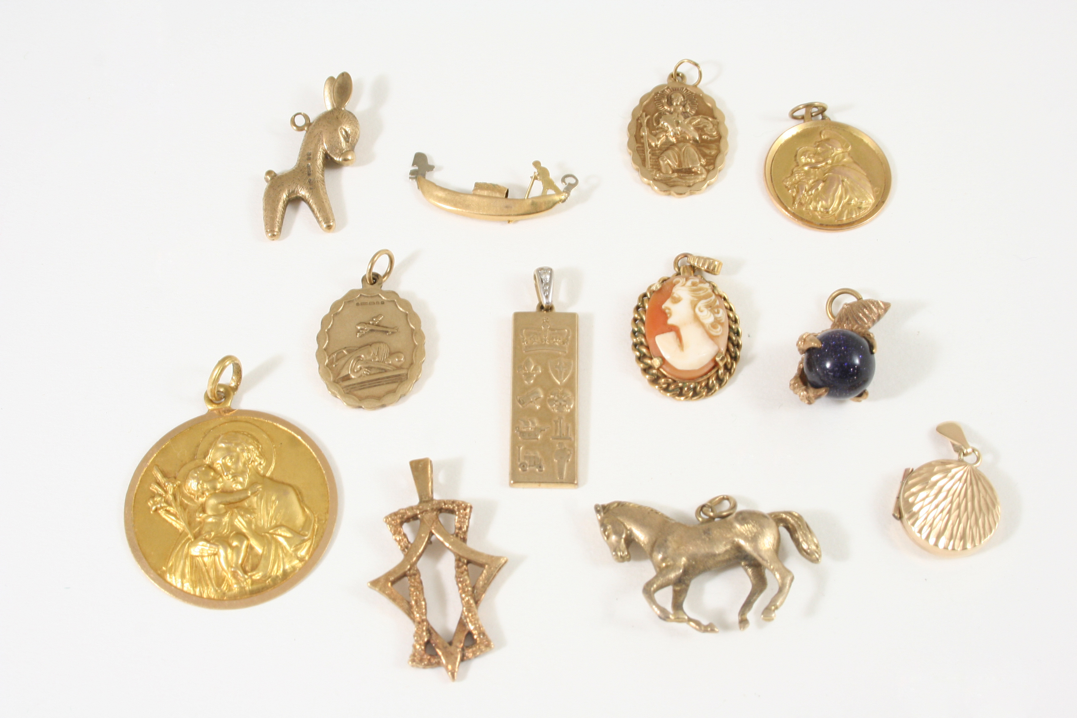 A QUANTITY OF GOLD JEWELLERY including a 9ct. gold pendant, embossed with various emblems, 5.9