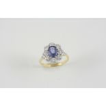 A SAPPHIRE AND DIAMOND CLUSTER RING the oval-shaped sapphire is set within a surround of eight