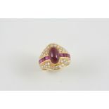A RUBY AND DIAMOND CLUSTER RING the oval cabochon ruby is set within a surround of calibre-cut