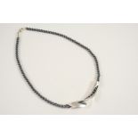 A SILVER NECKLACE BY GEORG JENSEN formed as a scrolling pendant on a bead necklace, 38cm. long, with