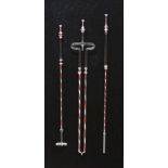 FRAMED SET OF THREE GLASS FRIGGER FIRE IRONS, with red and white barley twist decoration to the