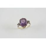 AN AMETHYST AND DIAMOND RING the oval-shaped amethyst is set with three rose-cut diamonds to each