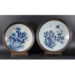 TWO CHINESE BLUE AND WHITE CHARGERS, painted with birds in flowering foliage inside a 'copper'