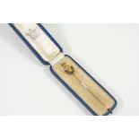 A GOLD AND ENAMEL PRINCE OF WALES FEATHERS STICK PIN decorated with blue and red enamel. In a