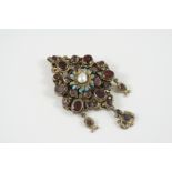 AN AUSTRO-HUNGARIAN GEM SET BROOCH PENDANT mounted with oval-shaped garnets to the silver gilt