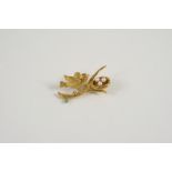 AN 18CT. GOLD AND GEM SET BROOCH formed as a bird on a branch with its nest, set with a circular-cut