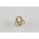 AN OPAL AND DIAMOND CLUSTER RING the oval solid white opal is set within a surround of old-cut