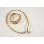 A 9CT. GOLD SNAKE NECKLACE realistically formed, with ruby eyes, 35.5cm. long, 31 grams, together