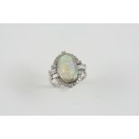 AN OPAL AND DIAMOND CLUSTER RING the oval-shaped solid white opal is set within a surround of