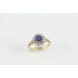 A SAPPHIRE AND DIAMOND CLUSTER RING the circular-cut sapphire is set within a surround of old