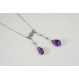 AN EDWARDIAN AMETHYST AND DIAMOND NECKLACE formed with two pear-shaped amethyst drops suspended from