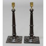 PAIR OF GEORGE III MAHOGANY CANDLESTICKS, the brass sconce above a fluted column with twisting lower