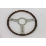 LES LESTON - VINTAGE CAR STEERING WHEEL a wood and aluminium 3 spoke wheel, circa 1960's. Stamped LL