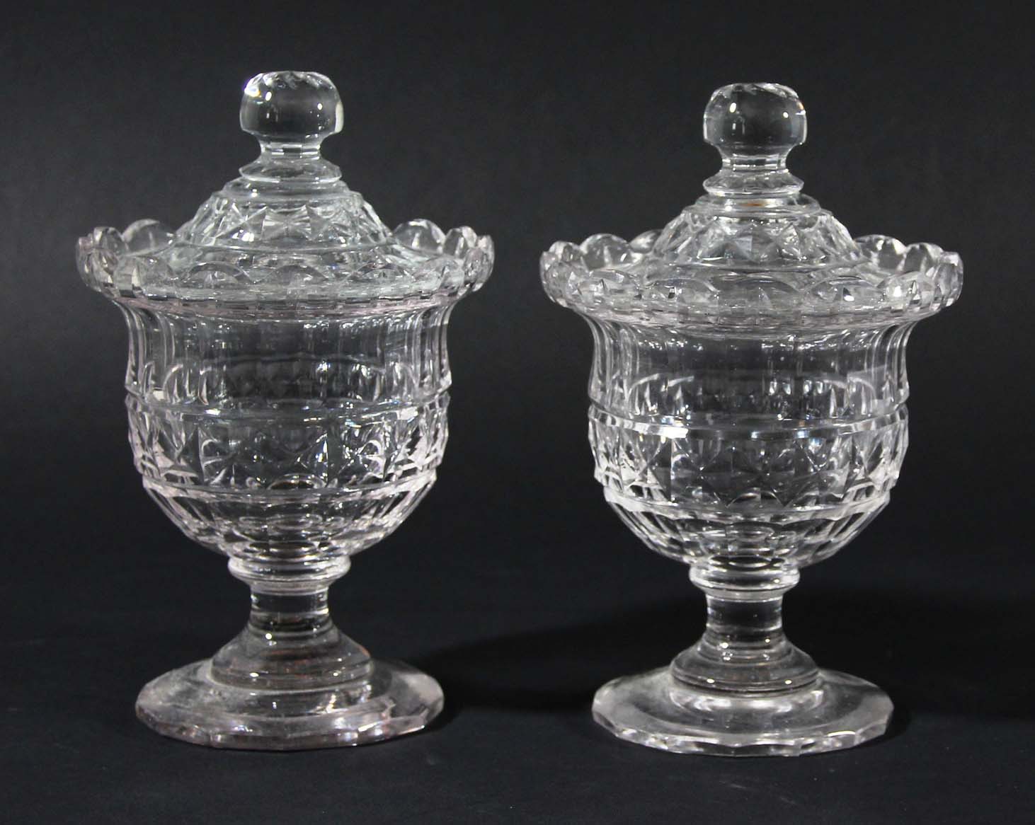 PAIR OF LATE GEORGIAN CUT GLASS HONEY JARS AND COVERS, of footed urn form with faceted decoration,