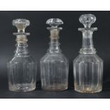 GROUP OF THREE GEORGIAN GLASS DECANTERS AND STOPPERS, with ring necks and fluted bodies, height 27-