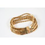 AN 18CT. GOLD BRACELET formed with six rows of rectangular-shaped flexible links, to a concealed