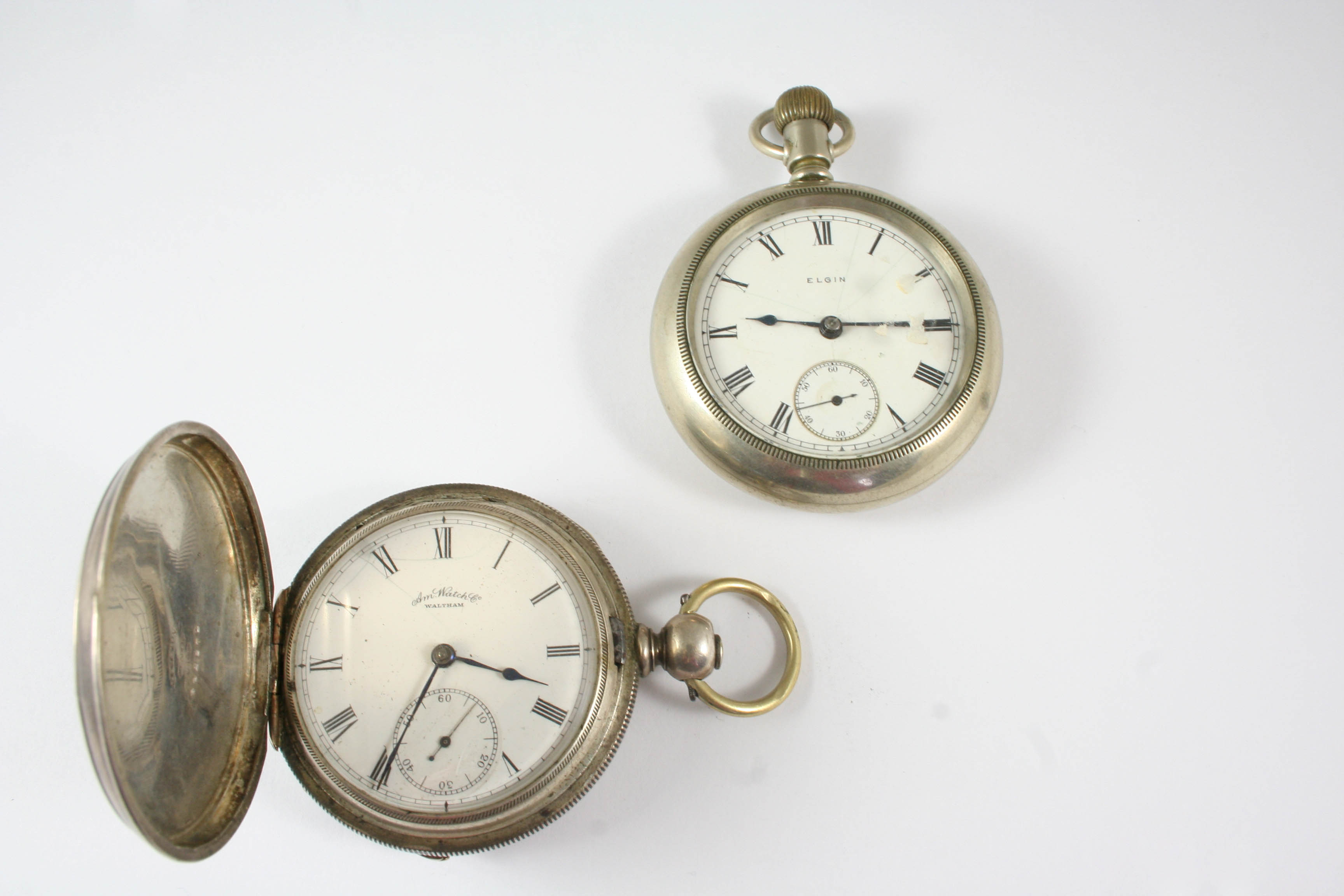 A METAL OPEN FACED POCKET WATCH BY ELGIN the signed white enamel dial with Roman numerals and