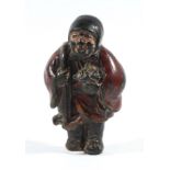 JAPANESE CARVED AND LACQUERED WOODEN NETSUKE OF A TRAVELLER, 19th century, .the hooded figure