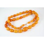 A SINGLE ROW GRADUATED AMBER BEAD NECKLACE 90cm. long, 149.5 grams.