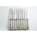 A SET OF TEN GEORGE III DESSERT OR SIDE KNIVES with Feather-edge & Shell pattern handles, crested,