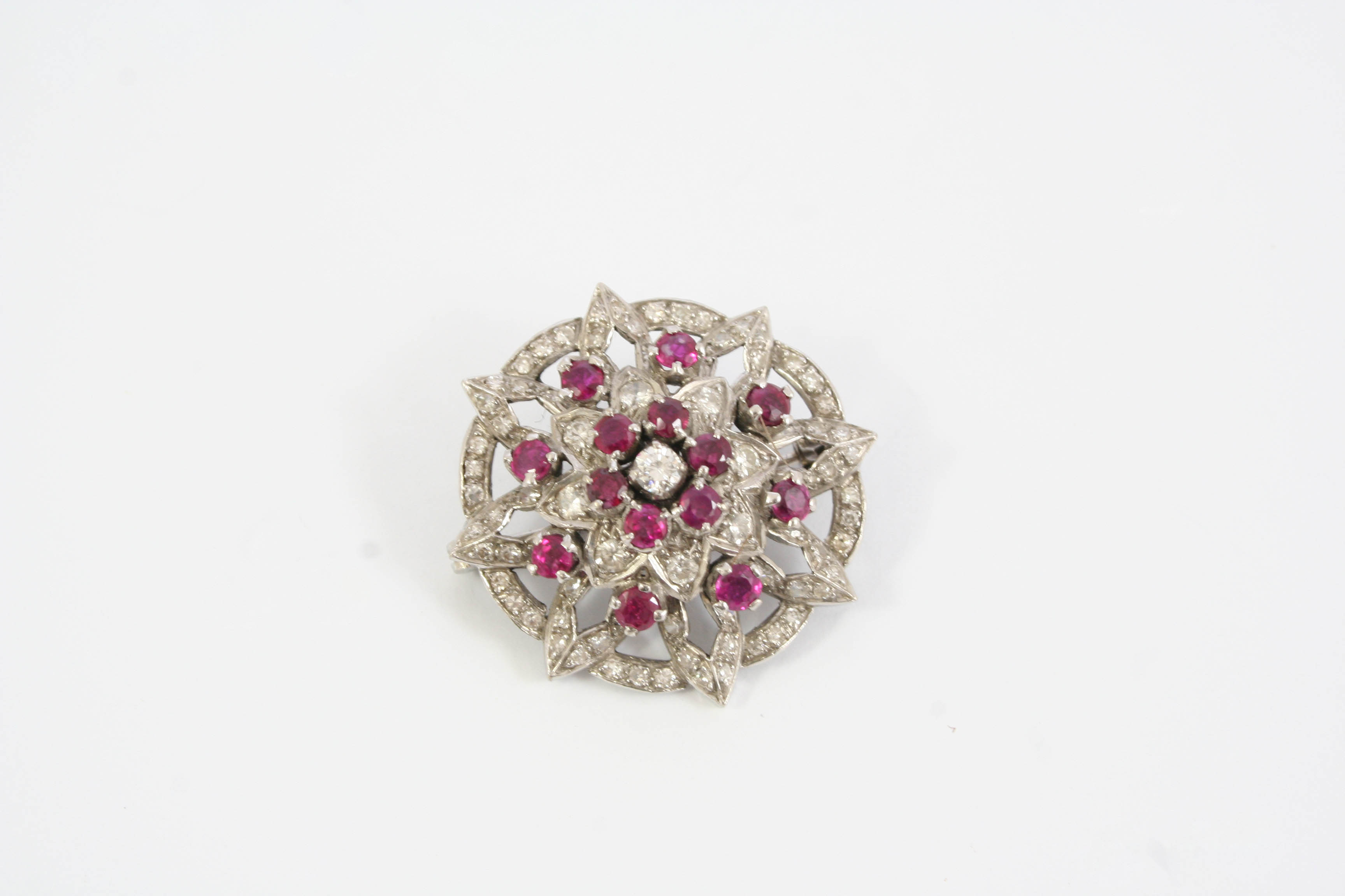 A RUBY AND DIAMOND BROOCH the flowerhead design is set overall with circular-cut rubies and