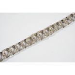 A HEAVY 18CT. WHITE GOLD AND DIAMOND BRACELET the graduated overlapping links are mounted with