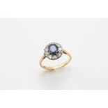 A SAPPHIRE AND DIAMOND CLUSTER RING the oval-shaped sapphire is set within a surround of old