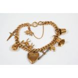 A 15CT. GOLD CURB LINK BRACELET suspending assorted 9ct. gold charms, total weight 50 grams.