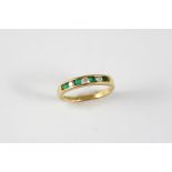 AN EMERALD AND DIAMOND HALF HOOP RING set alternately with circular-cut emeralds and diamonds in