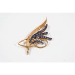 A SAPPHIRE AND GOLD FOLIATE SPRAY BROOCH mounted with circular-cut sapphires and gold leaves, in