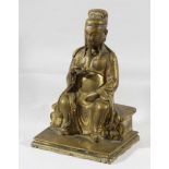 GILT BRONZE FIGURE OF A SEATED IMMORTAL, probably Chinese, the figure seated on a bench, height