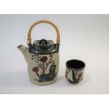 JOHN MALTBY (BORN 1936) a stoneware teapot of slender shape, painted with various motifs to both