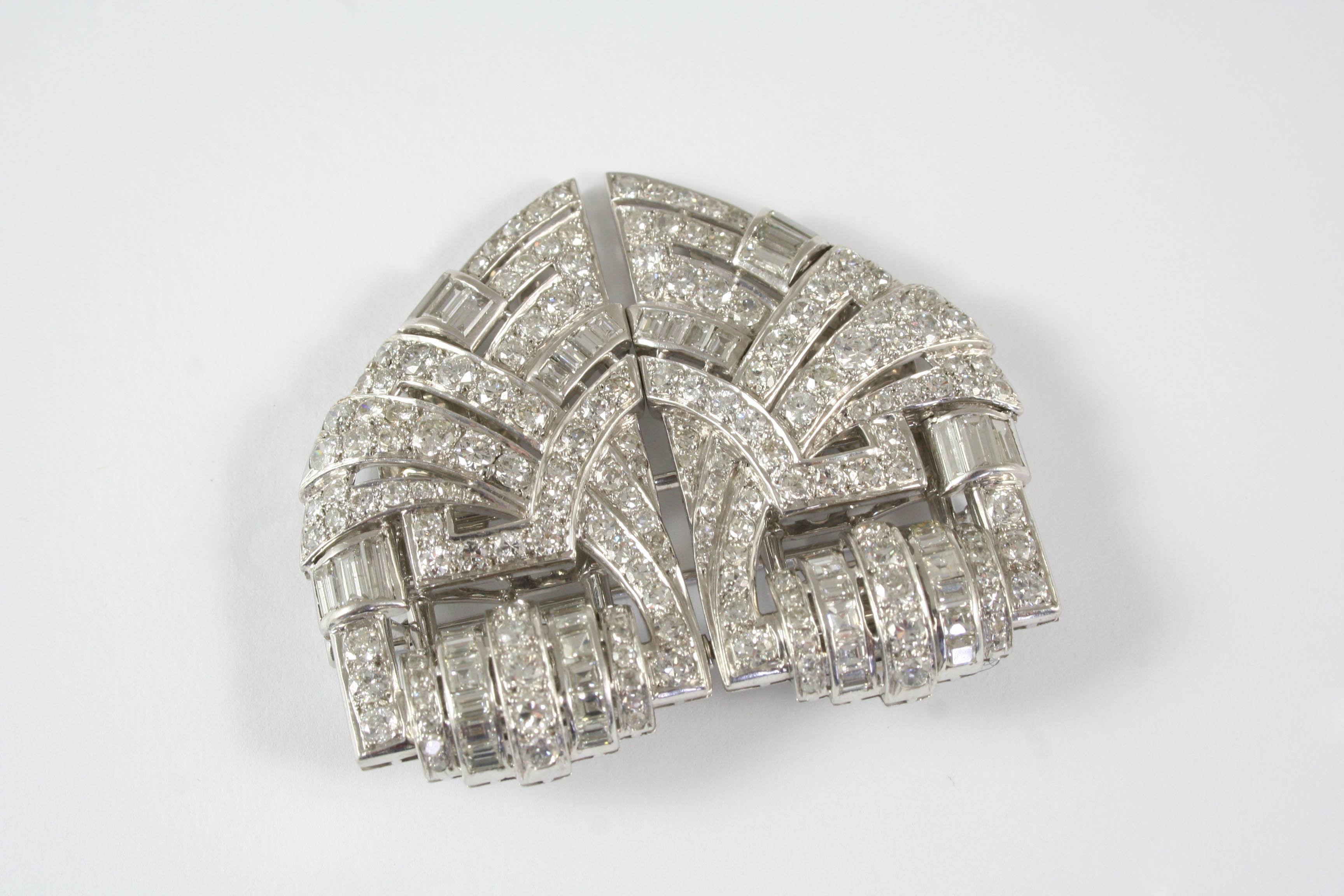 AN ART DECO DIAMOND DOUBLE CLIP BROOCH the arched openwork scrolling design is mounted with