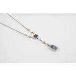 AN ART DECO SAPPHIRE AND DIAMOND PENDANT the two oval-shaped sapphires are suspended from knife edge
