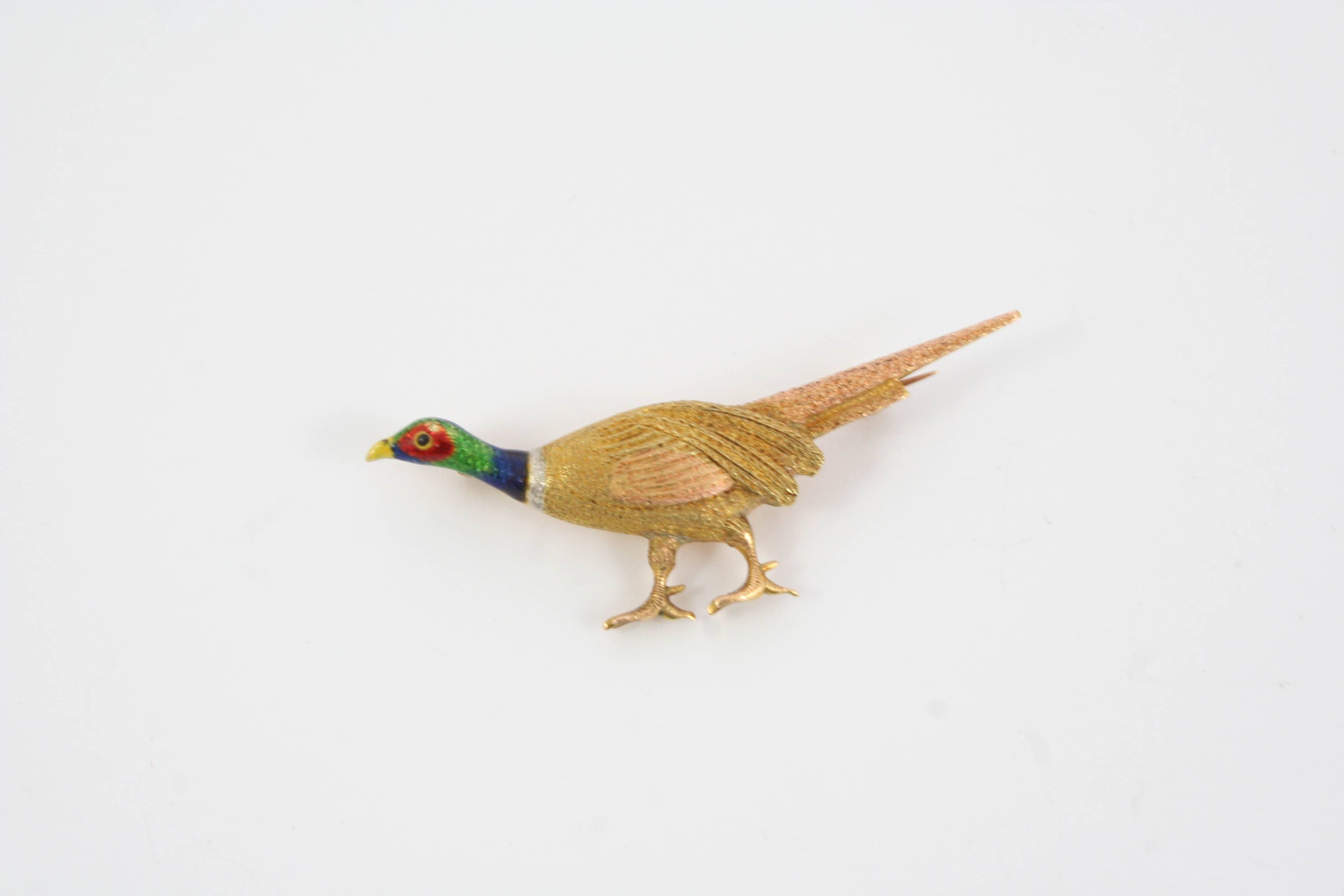 AN ENAMEL AND 15CT. GOLD PHEASANT BROOCH realistically formed, the head with green, blue and red