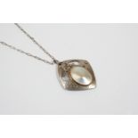 A MOTHER OF PEARL AND SILVER PENDANT BY MURRLE BENNETT & CO. the openwork hammered silver mount is